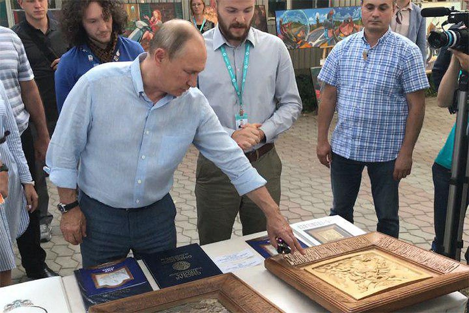 Путин осмотрел стенд, где были представлены деревянные резные иконы