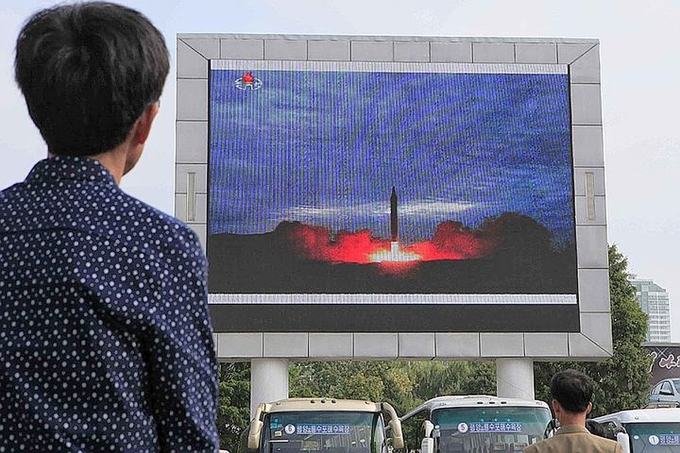 Житель Северной Кореи наблюдает за сюжетом об успешном испытательном запуске ракеты на экране в Пхеньяне