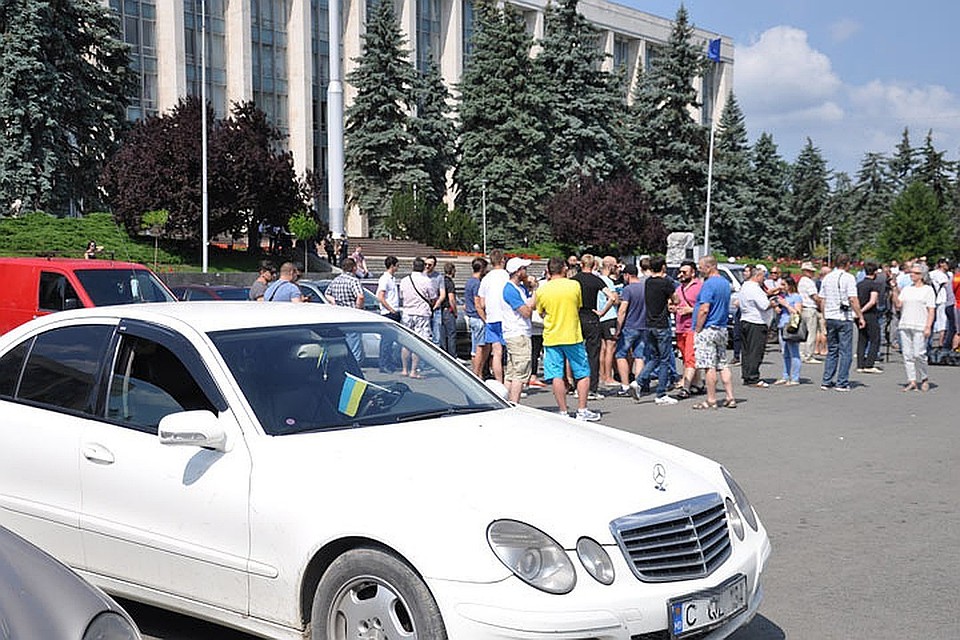 Машины стояли в ряд, люди собрались кругом, возмущались, проезжающие мимо автомобили сигналили в поддержку протестующих