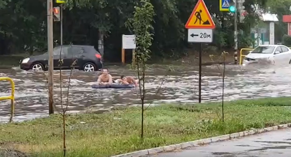 Двое молодых людей нашли свой способ передвижения по превратившемся в реки дорогам