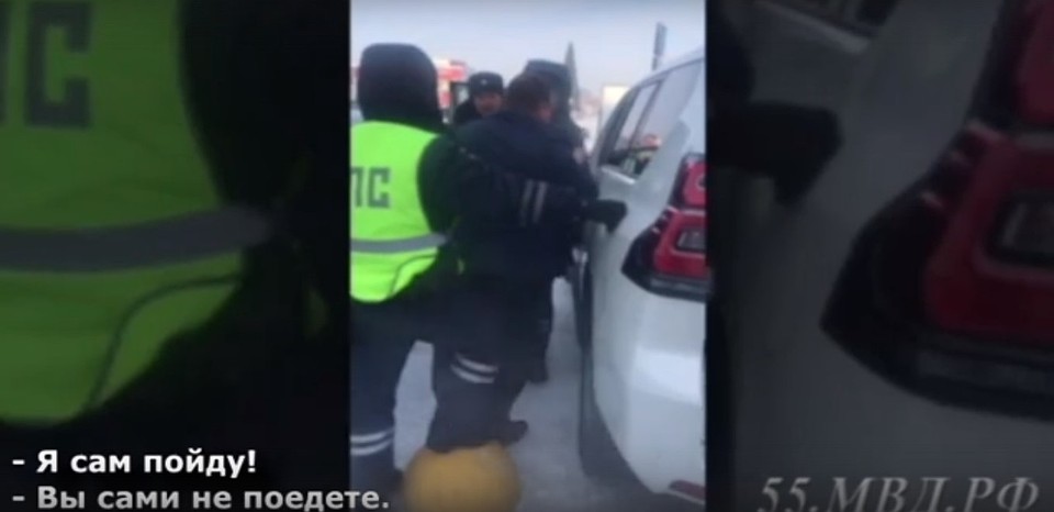 Инспекторы силой вытащили из машины омича, не дававшего ее эвакуировать