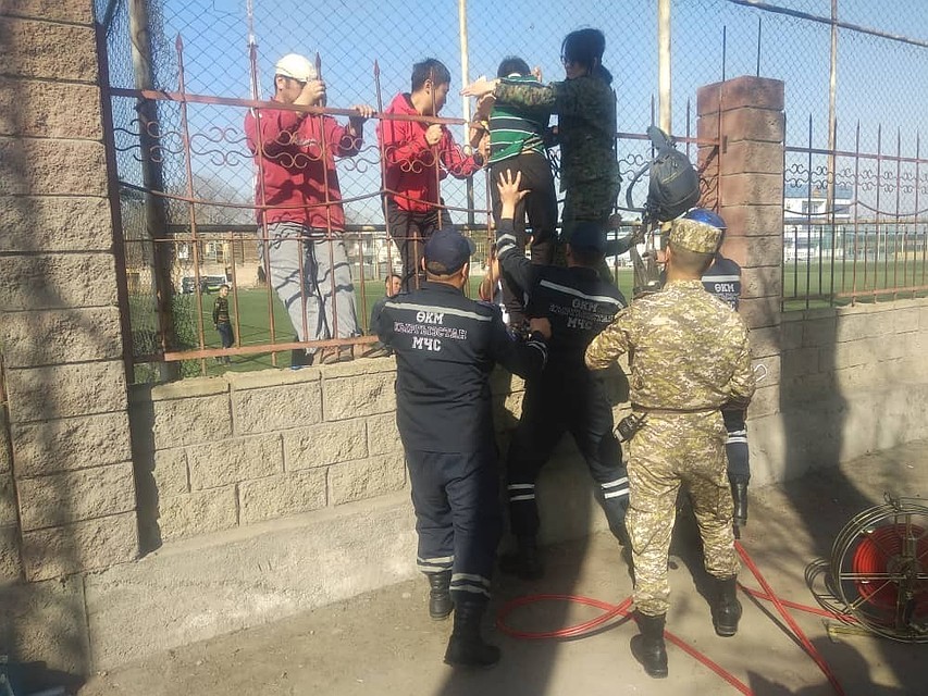 Мальчик повис на одном из прутьев забора