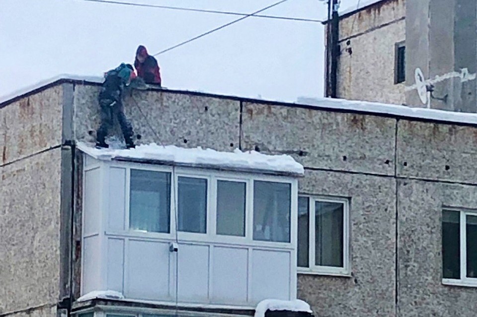 Снег с балкона "падал" под контролем жилищников. Фото: "Мурманск. Официальная группа"