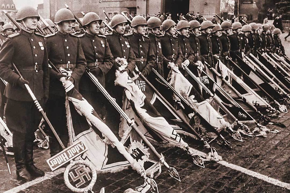 24 июня 1945 года. Первый Парад Победы. По предложению Сталина он завершался складированием флагов поверженных гитлеровских войск к подножию Мавзолея. Знамена и штандарты врага пронес сводный батальон из 200 советских солдат. Идея «публичной казни» вражеских знамен была заимствована у великого полководца Александра Суворова, в войсках которого был ритуал «небрежения не к неприятелю, а к его поверженным военным отличиям». Слева на фото - сержант Федор Легкошкур с древком штандарта дивизии СС «Адольф Гитлер», он первым с презрением швырнул фашистское древко на мокрый асфальт. Само полотнище штандарта было привезено в Москву из Берлина уже после Парада.