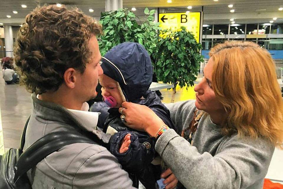 Соня Миримская на руках у старшего брата в аэропорту Шереметьево. Справа - мама девочки Ольга Миримская. Фото Яны Лантратовой.