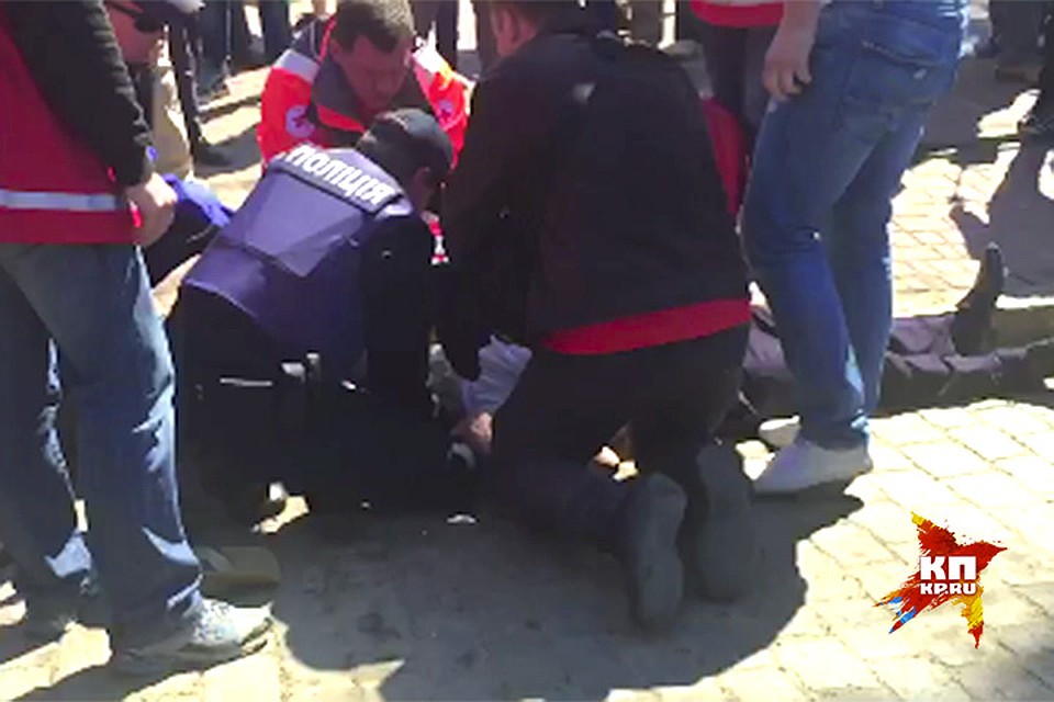 Пожилой человек простоял с цветами около 8 часов и упал. Полицейские и медики пытаются оказать ему первую помощь. Не помогло... Фото: Владимир ВОЛОШИН