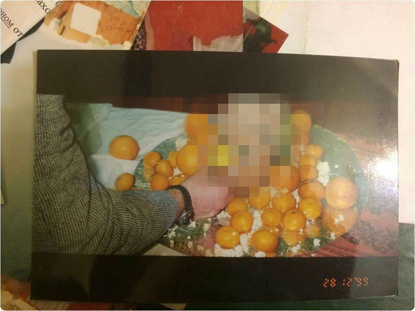 На одной из карточек на усыпанном мандаринами блюде лежит приготовленная голова человека.