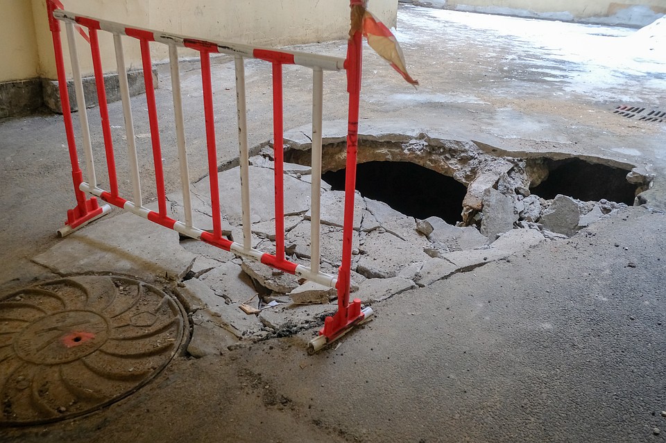 Во дворе виднеются дыры в асфальте