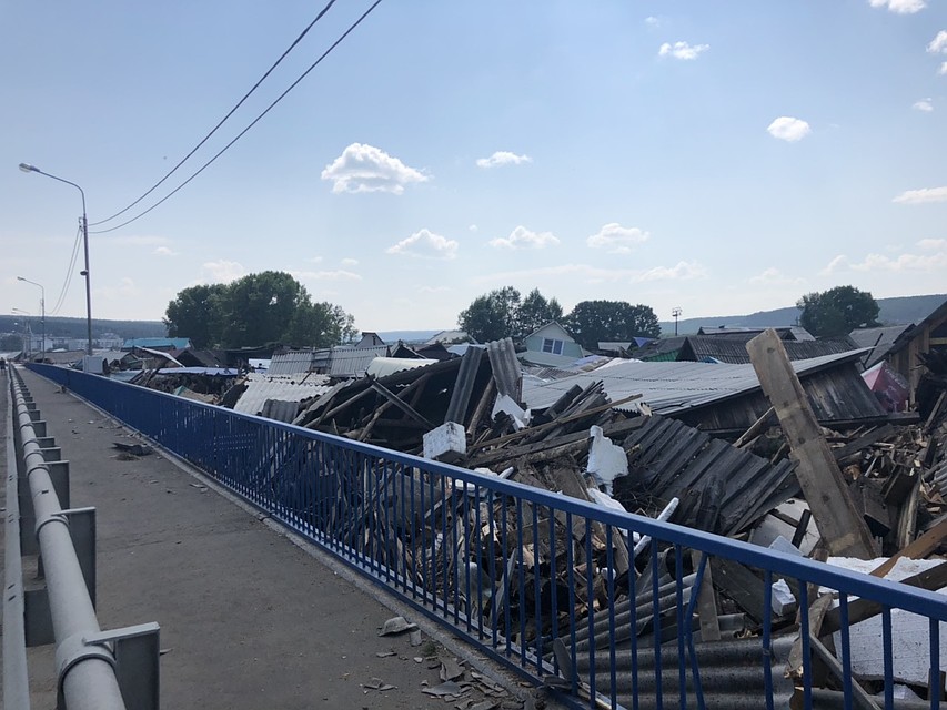 Смытые наводнением дома прибило к мосту.