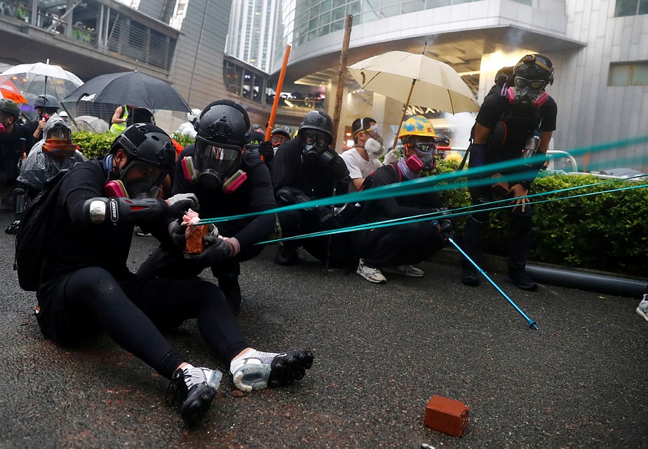 Протестующие с помощью рогаток обстреливают полицию. Фото: REUTERS