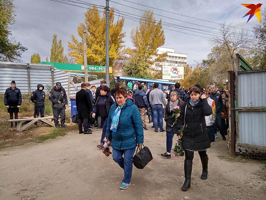 Из подъезжающих автобусов выходят все новые десятки людей с цветами Фото: Екатерина Семенова