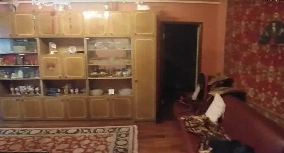 В гостиной - кожаная мебель и скромная стенка с фарфором. Фото: стоп-кадр видео СК РФ.