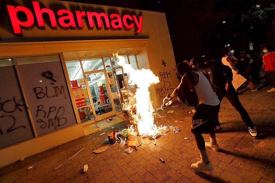 Протестующие пытаются поджечь аптеку, Миннеаполис, 31 мая 2020 г. Фото: REUTERS