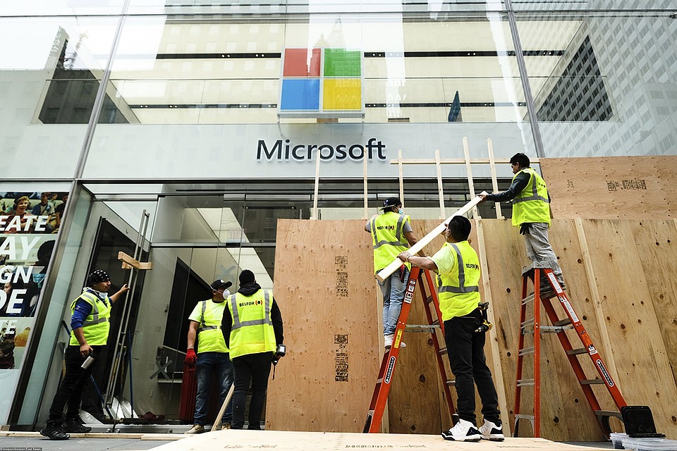 От ночных погромов пострадал и официальный магазин Microsoft, располагающийся на Пятой авеню в Нью-Йорке. На утро рабочие заколотили разбитые стекла фанерными листами. Фото: REUTERS