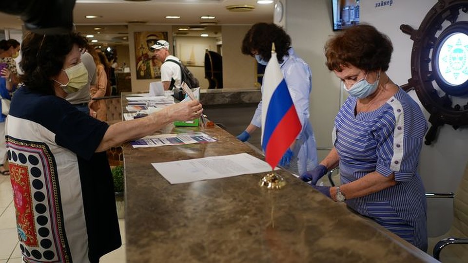 Сотрудницы комиссии в масках и перчатках проверяют документы, сверяют данные паспорта, делают отметки в списках и выдают бюллетени. Фото: Юлия БАРАНОВА
