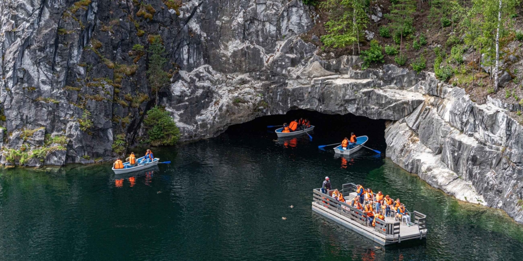 туристы плывут по мраморному озеру