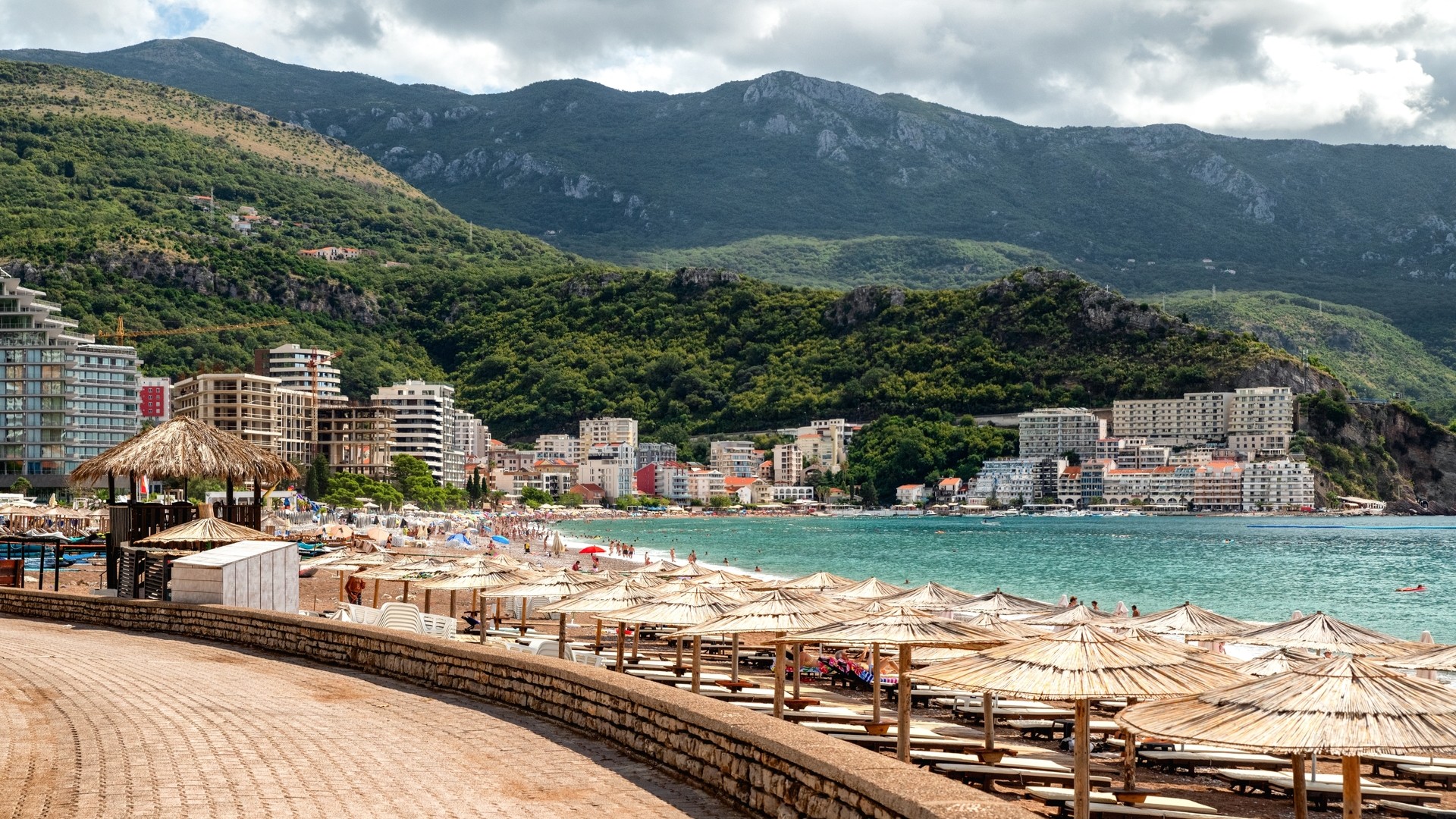 Отели, зонтики с шезлонгами на песчаном пляже курорта Бечичи.